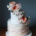 Signature ruffle wedding cake with fresh floral arrangement