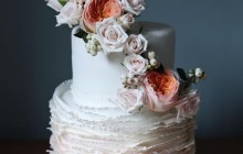 Signature ruffle wedding cake with fresh floral arrangement