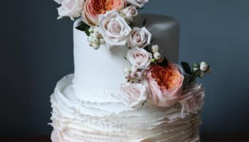 Signature ruffle wedding cake with fresh floral arrangement
